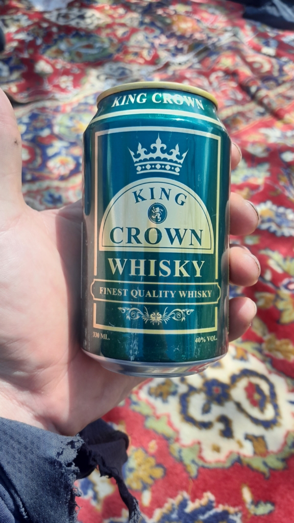 Eine grüne Dose Whisky in der Hand