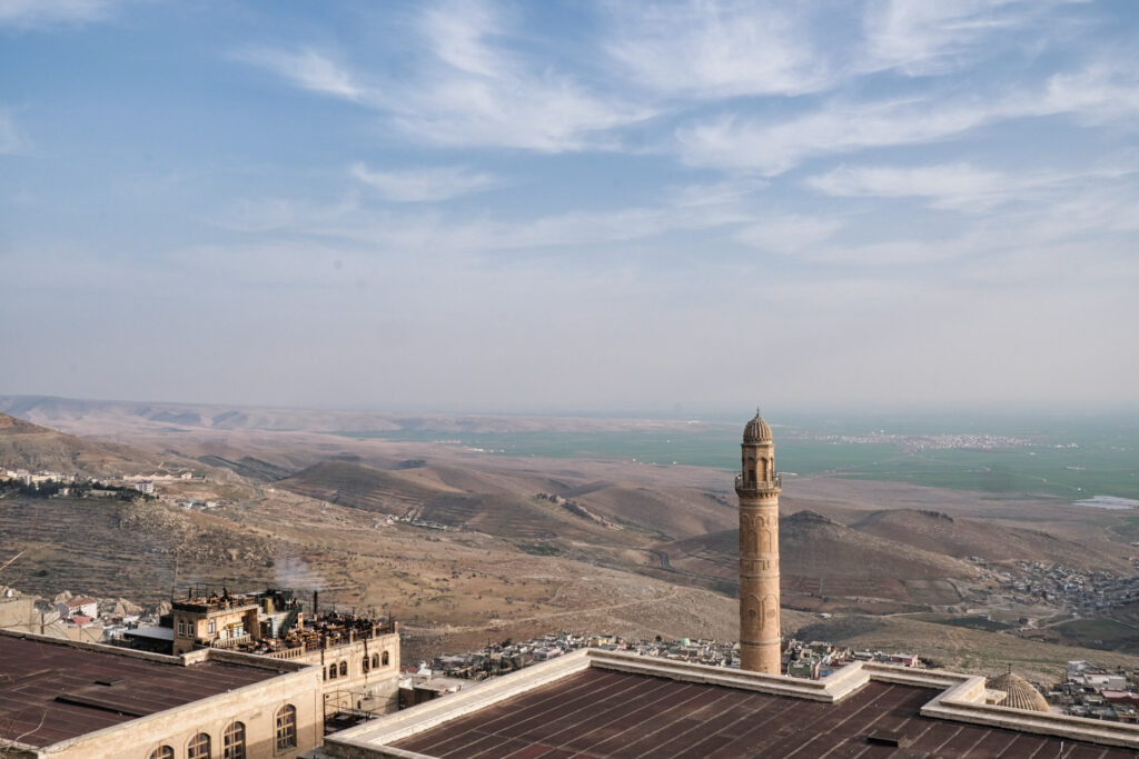Weitblick von der Höhe Mardins hinunter auf die flachen, grünen Wiesen in Syrien.