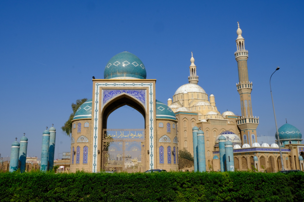 Moschee mit blauen Kacheln und detaillierten Ornamenten vor klarem Himmel.