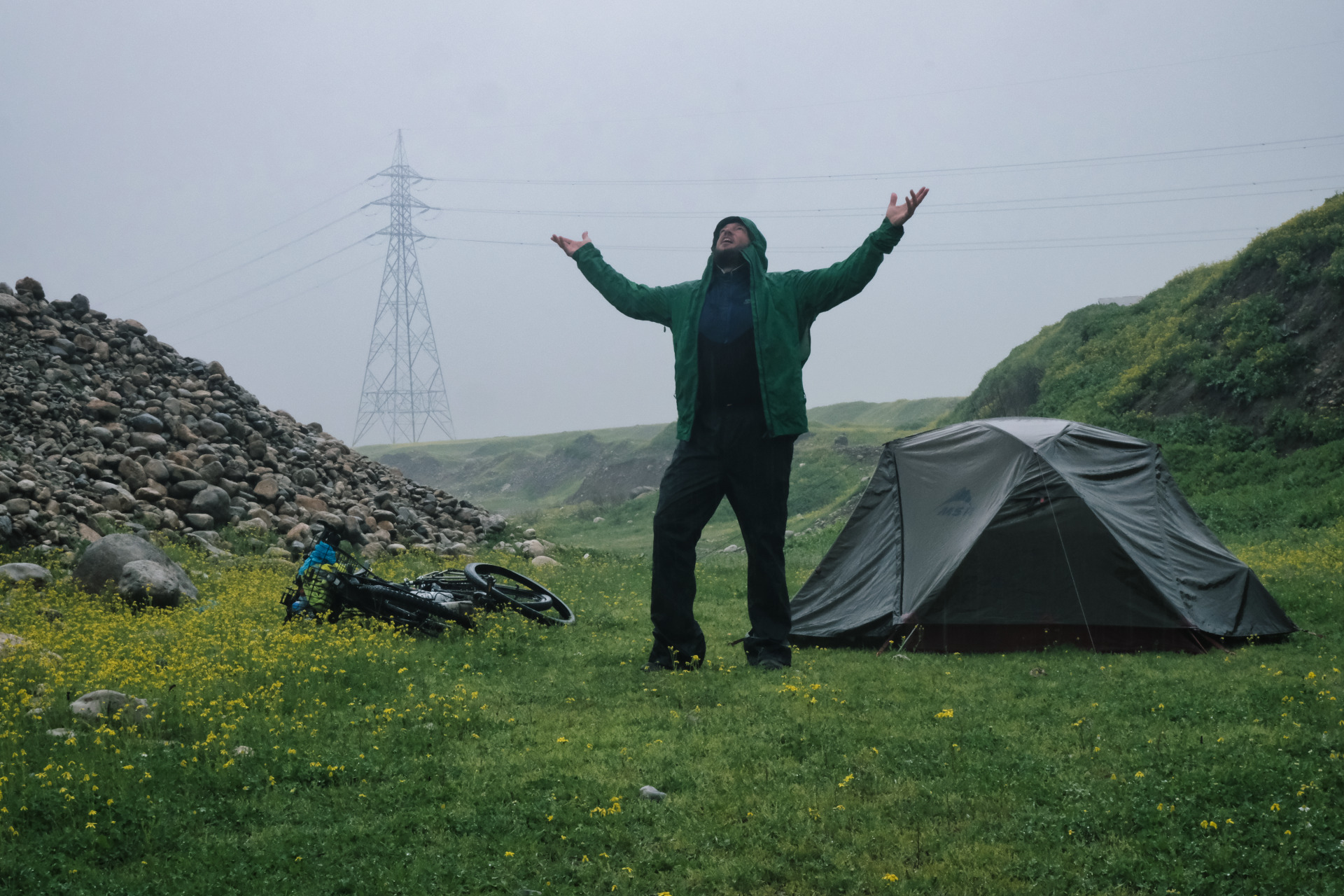 Neben dem Zelt stehe ich im Regen und strecke verzweifelt die Arme nach oben