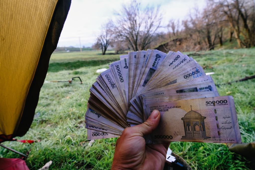 Meine Hand hält einen nicht zählbaren Fächer an 500.000 Rial Banknoten