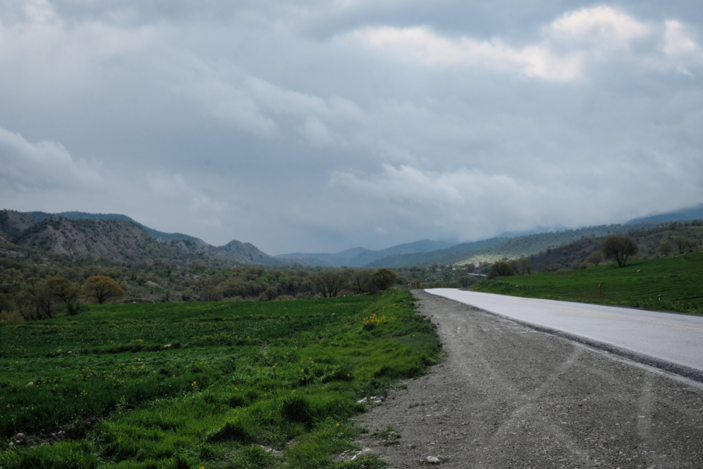 Enge, verregnete Straße, die dem Tal entlang bergauf führt.