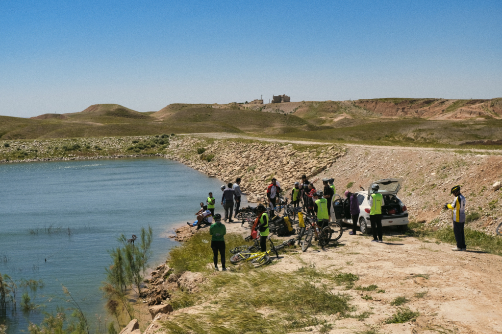 Eine Gruppe Fahrradfahrer baut ihren Picknickplatz an einem See an einer Steppe auf