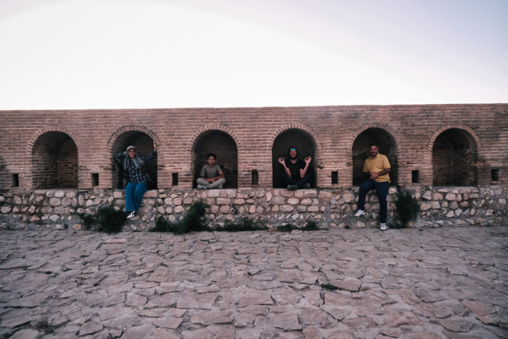 Wir sitzen jeweils in einem kleinen Torbogen in einer Burg und posieren für die Kamera.