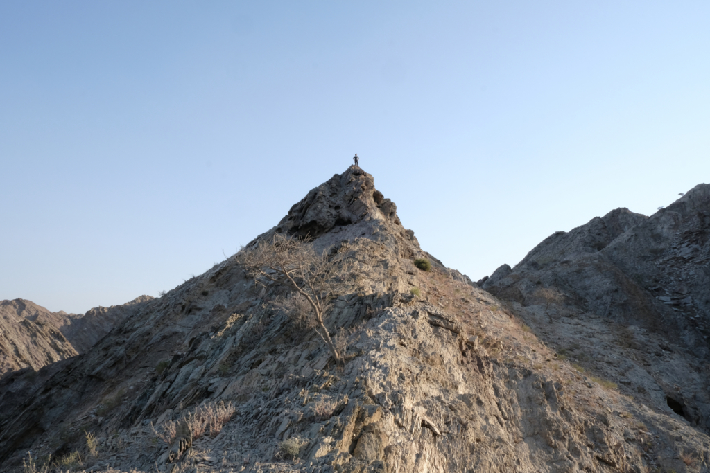in spitz zulaufender Berg dominiert das Bild. Ich stehe auf dessen Spitze.