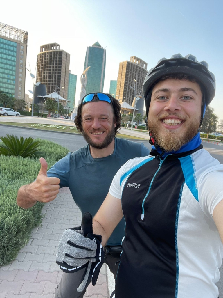 Shad und ich stehen mit Daumen nach oben, vor einem neu gebauten Shad und ich stehen mit erhobenem Daumen vor einem neu gebauten Hochhauskomplex